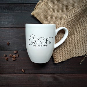 May include: White ceramic mug with a black design that says "JESUS The King of Kings" with a crown above the word "JESUS".