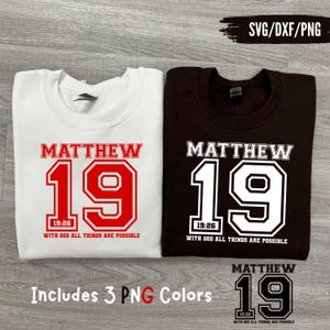Könnte beinhalten: Zwei Sweatshirts, eines weiß und eines braun, jeweils mit dem Text "MATTHÄUS 19" in einer College-Schriftart. Unter der Zahl 19 steht "19:26 MIT GOTT SIND ALLE DINGE MÖGLICH". Das Bild enthält auch eine kleine Grafik und den Text "Enthält 3 PNG-Farben".