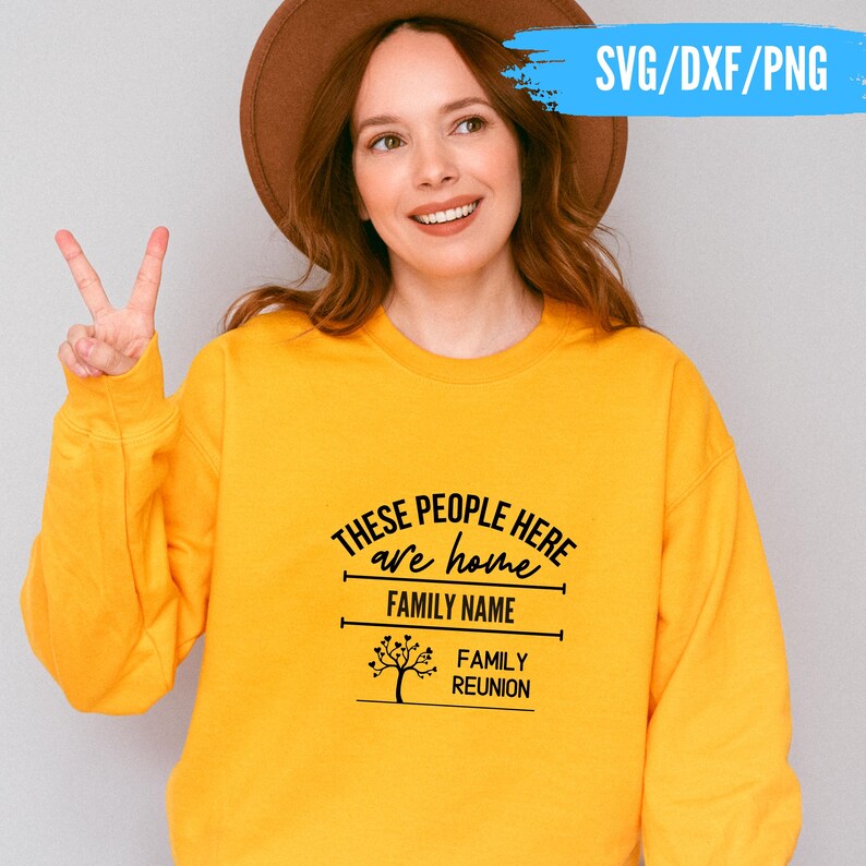 May include: A yellow sweatshirt with the text "THESE PEOPLE HERE are home FAMILY NAME FAMILY REUNION" in black. The sweatshirt has a crew neck and long sleeves. The image also includes a woman wearing a brown hat.