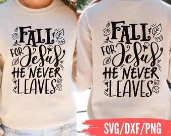 May include: Cream-colored sweatshirt with the text "FALL FOR Jesus HE NEVER LEAVES" in black script and decorative leaf and heart accents. The back of the sweatshirt also displays the same text. The image also includes the text "SVG/DXF/PNG".