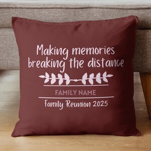 May include: A maroon throw pillow with white text that reads "Making memories breaking the distance." Below the text is a floral design and the words "FAMILY NAME" and "Family Reunion 2025."