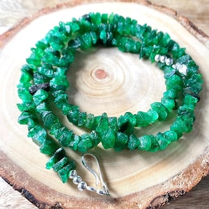 Può includere: Una collana di pietre preziose smeraldo verde con una chiusura in argento. La collana è realizzata con piccole pietre smeraldo di forma irregolare.