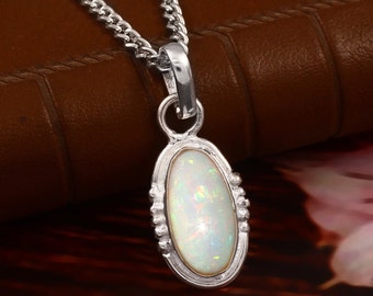May include: A silver chain necklace with a pendant featuring a white opal stone set in a silver oval frame.
