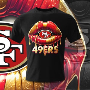 May include: Black t-shirt featuring a red and gold dripping lip design. The lip contains a gold and red 'SF' logo. The text '49ers' is positioned below the lip.