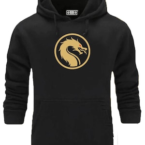 Peut inclure: Sweat-shirt à capuche noir avec un logo de dragon doré dans un cercle. Le dragon a les yeux rouges.