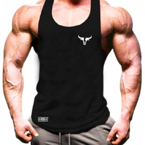 Puede incluir: Camiseta sin mangas negra con un logotipo de toro blanco en el pecho. La camiseta sin mangas es sin mangas con cuello redondo. Un logotipo rectangular blanco está en la parte inferior izquierda. La camiseta sin mangas está hecha de un material suave y cómodo.