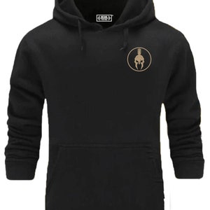 May include: Black hooded sweatshirt with a gold Spartan helmet graphic in a circle on the left chest. The text "Fitness Thing" is on the tag.