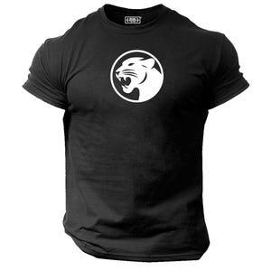 Könnte beinhalten: Schwarzes T-Shirt mit Rundhalsausschnitt und weißem, kreisförmigem Motiv eines brüllenden Panthers. Das Shirt hat kurze Ärmel und ein Etikett oben.