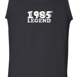 Peut inclure: Un débardeur noir sans manches avec du texte blanc qui dit "1985 LEGEND".