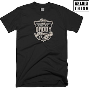 Könnte beinhalten: Schwarzes T-Shirt mit einem weißen Aufdruck, der "Keep Calm and Let Daddy Handle It" lautet.