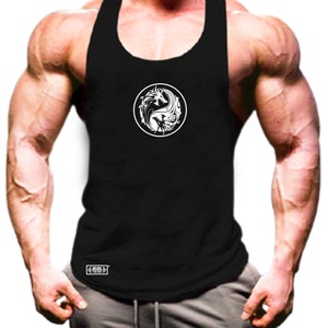 May include: Black tank top with a white circular graphic featuring a dragon and flame design. The tank top is sleeveless and has a scoop neck. The bottom left corner of the tank top has a small white rectangular logo.