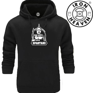 Op de afbeelding: Zwart hoodie met een witte afbeelding van een Spartaanse krijger die een speer vasthoudt en het woord "SPARTANS" eronder. Het Iron Heaven logo staat rechtsboven.