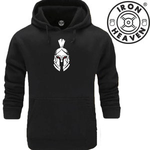 Peut inclure: Sweat-shirt à capuche noir avec un graphique de casque de spartiate blanc et le texte "IRON HEAVEN" dans un cercle avec un symbole de poids.