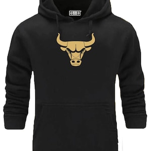 Peut inclure: Sweat-shirt à capuche noir avec un logo de tête de taureau dorée sur le devant. Le sweat-shirt a une capuche avec cordon de serrage et une poche kangourou.