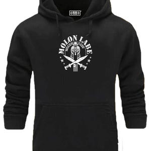 Könnte beinhalten: Schwarzer Kapuzenpullover mit weißem Aufdruck. Der Aufdruck zeigt den Text "MOLON LABE" um einen spartanischen Helm und gekreuzte Schwerter. Der Pullover hat eine Vordertasche und eine Kapuze mit Kordelzug.