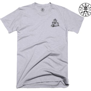 May include: A heather grey t-shirt with a black and white graphic of an all-seeing eye inside a pyramid with a snake wrapped around it. The graphic is on the left side of the shirt. The shirt has a crew neck and short sleeves.