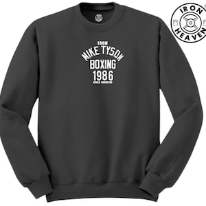 May include: A dark gray sweatshirt with a white graphic print that reads "Iron Mike Tyson Boxing 1986 World Champion".