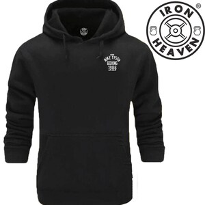 May include: Black hooded sweatshirt with a white logo that says "MIKE TYSON BOXING 1986". The logo is on the left chest of the sweatshirt. The sweatshirt has a kangaroo pocket and a drawstring hood.