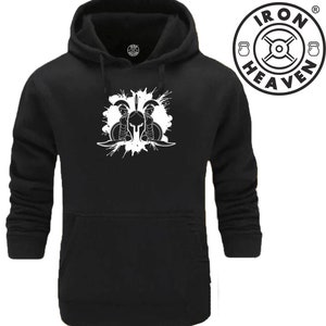 Op de afbeelding: Zwarte hoodie met een witte afbeelding van een Spartaanse helm met zwaarden en een splatterontwerp. De tekst "IRON HEAVEN" staat in een cirkel met een halterstang en halters.