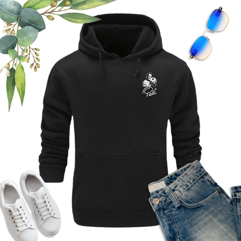May include: Black hooded sweatshirt with a white graphic of a soccer player holding a ball and the word "Pel&eacute;" underneath.