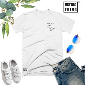 May include: White t-shirt with a black and white illustration of a dinosaur holding a cup, with the text "TEA-REX" above it.