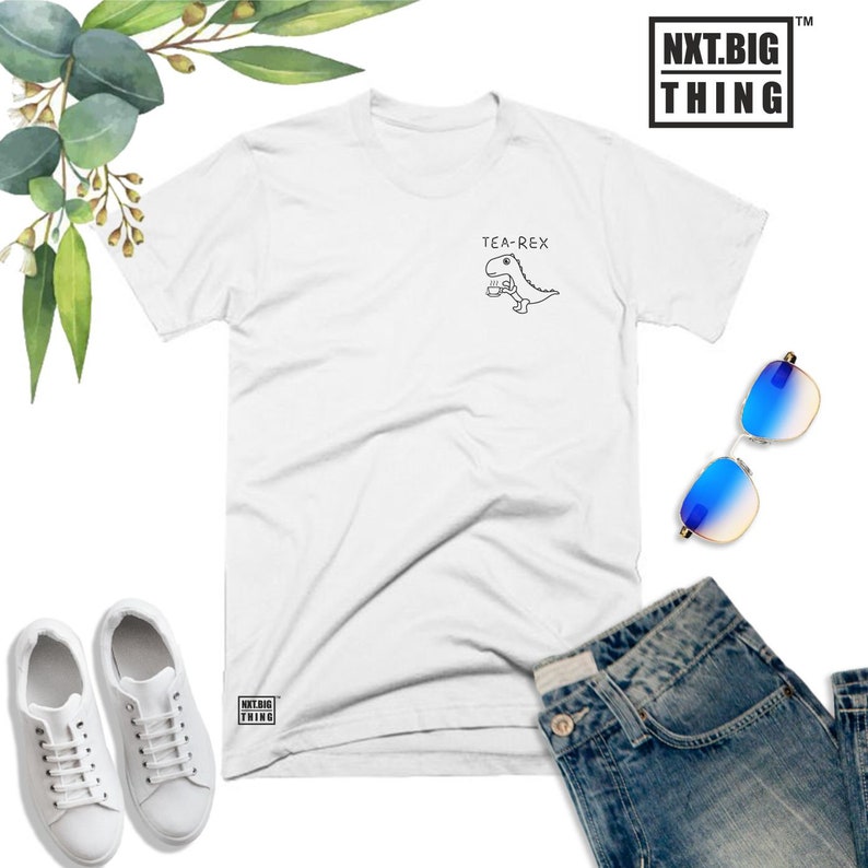 May include: White t-shirt with a black and white illustration of a dinosaur holding a cup, with the text "TEA-REX" above it.