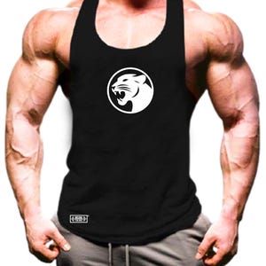 Könnte beinhalten: Schwarzes Tanktop mit einem weißen kreisförmigen Logo, das einen brüllenden Panther zeigt. Das ärmellose Oberteil hat einen Rundhalsausschnitt. Das Tanktop besteht aus einem weichen, atmungsaktiven Material, ideal für Workouts.