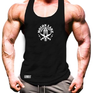 Könnte beinhalten: Schwarzes Tanktop mit weißem Aufdruck, der einen spartanischen Helm, gekreuzte Schwerter und den Text "MOLON LABE" zeigt. Das Tanktop ist ärmellos und aus weichem Material.