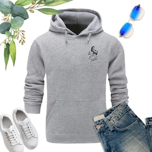 May include: A gray hooded sweatshirt with a black and white image of soccer player Pel&eacute; on the front. The text "Pel&eacute;" is printed below the image.