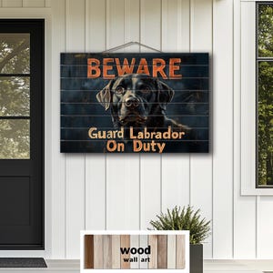May include: Wooden wall art sign with a black Labrador Retriever image. The sign reads "BEWARE Guard Labrador On Duty" in orange lettering. The sign is hanging on a white wall near a black door and window.