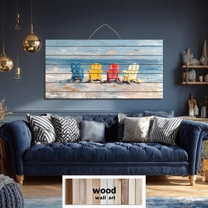 Puede incluir: Una obra de arte mural de madera que representa cuatro sillas Adirondack coloridas en una playa, con un fondo de océano y cielo azul. Las sillas son azules, amarillas, rojas y crema. El texto "wood wall art" está en la parte inferior.