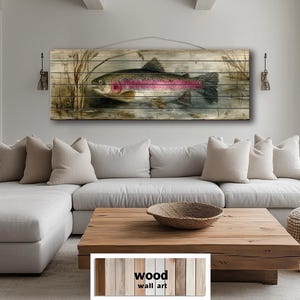May include: Wooden wall art featuring a detailed illustration of a rainbow trout in a naturalistic setting. The artwork is mounted on a wooden plank background with a neutral color palette, suitable for home decor. The text "wood wall art" is visible.