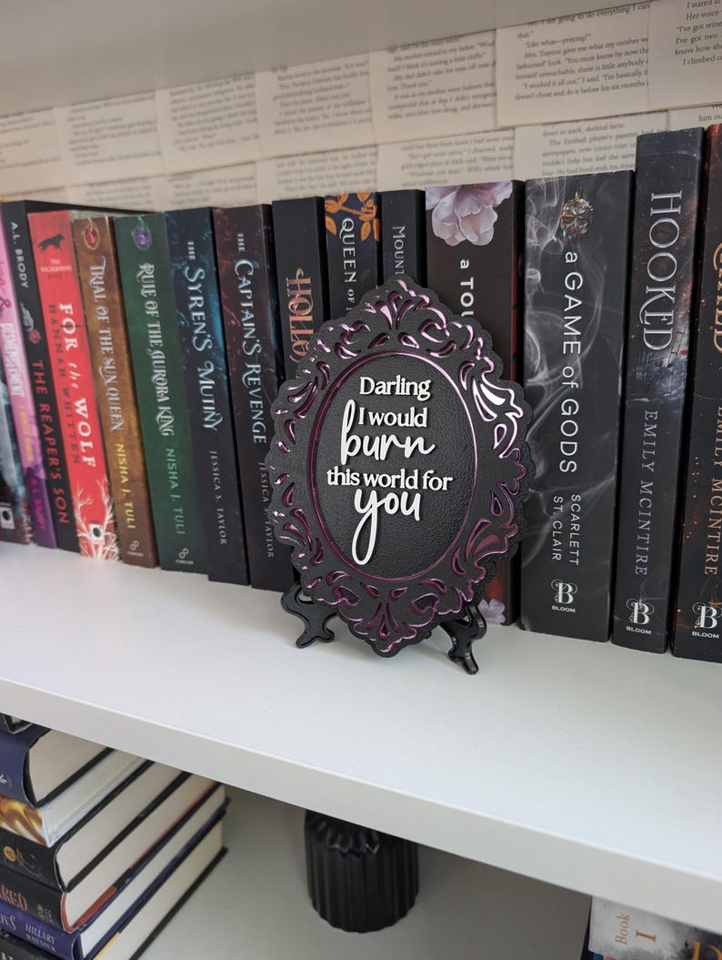 May include: A black framed decorative sign with a purple and black design. The sign has the text "Darling I would burn this world for you" in white lettering.