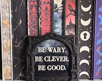 Letrero para estantería "Sé cauteloso, sé inteligente, sé bueno" / Licencia de Rachel Gillig One Dark Window