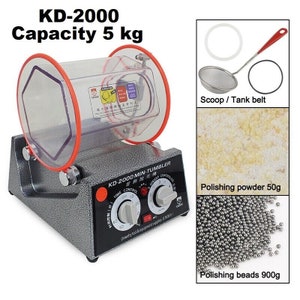 May include: A gray metal tumbler polisher with a clear plastic drum, red control knobs, and a black control panel labeled "KD-2000 MIN-TUMBLER". The polisher has a 5 kg capacity and includes a scoop, tank belt, 50g of polishing powder, and 900g of polishing beads.
