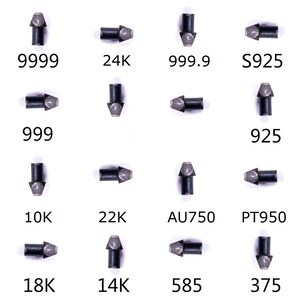 Puede incluir: Un conjunto de diecis&eacute;is agujas de prueba de metal con puntas afiladas, cada una marcada con &iacute;ndices de pureza como 9999, 24K, 999.9, S925, 999, 925, 10K, 22K, AU750, PT950, 18K, 14K, 585 y 375, dispuestas en una cuadr&iacute;cula sobre fondo blanco.