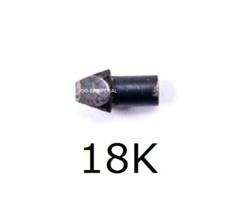 Puede incluir: Una peque&ntilde;a aguja de prueba de metal oscuro con una punta triangular y una base cil&iacute;ndrica. El texto 'GO EASY DEAL' est&aacute; impreso en el lateral y los caracteres '18K' aparecen en una fuente negra grande debajo del objeto.