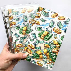 May include: A clear binder with a money-themed design. The design features illustrations of green dollar bills, gold coins, and stacks of cash. The words "DEBT PAYOFF" are printed on the bottom right corner of the design.