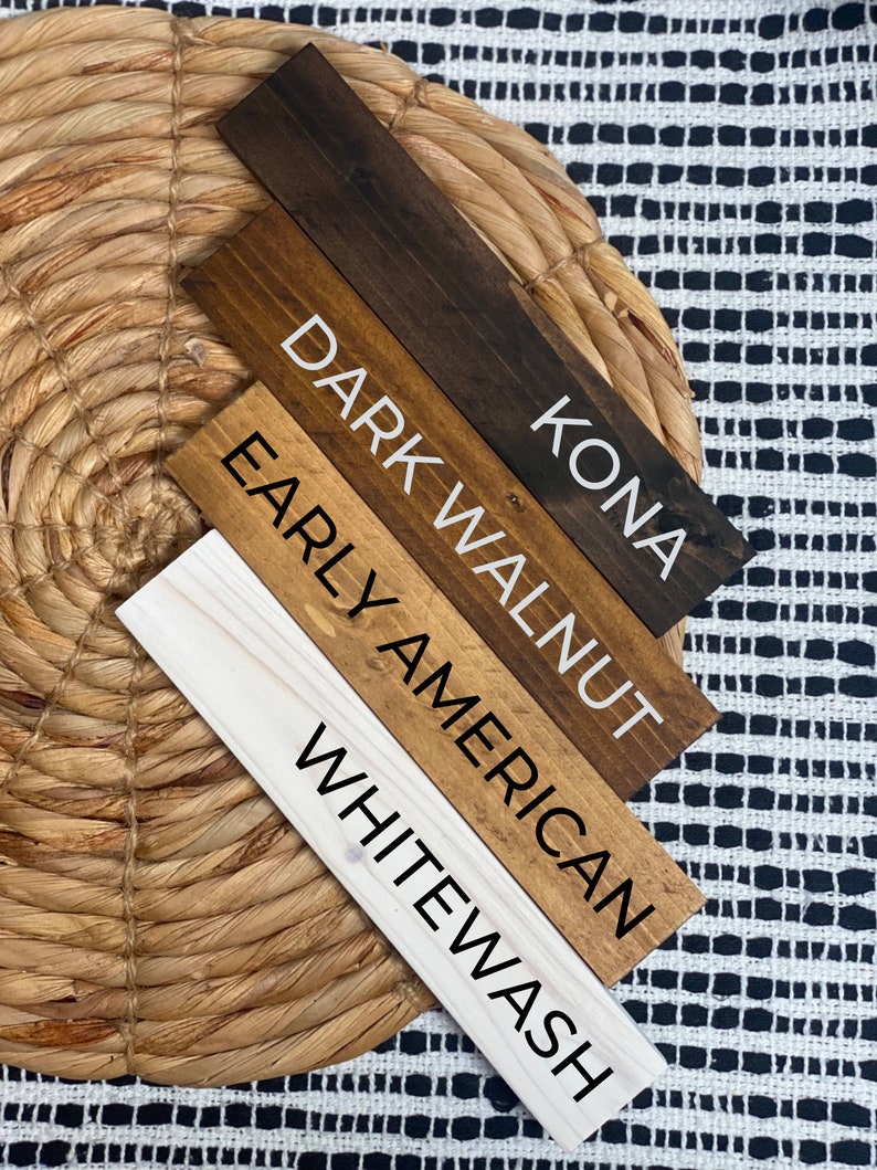 May include: Four wooden stain samples with the names Kona, Dark Walnut, Early American, and Whitewash written on them.