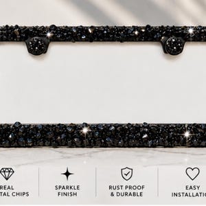 May include: A rectangular black license plate frame covered in dark, faceted crystal chips. The frame features two circular mounting points at the top. Below the frame, four icons are displayed with the text: REAL CRYSTAL CHIPS, SPARKLE FINISH, RUST PROOF & DURABLE, and EASY INSTALLATION.