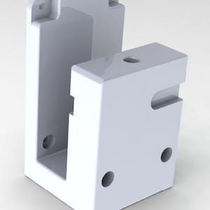 May include: White plastic box with a rectangular opening and several round holes. The box is designed to hold a small object.