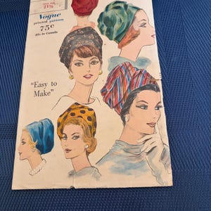 May include: A vintage Vogue printed pattern envelope, number 5332, featuring illustrations of various head wraps and turbans in solid red, teal, patterned dark fabric, multi-colored stripes, blue, and yellow with black polka dots.