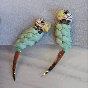 Op de afbeelding: Een set van drie keramische mokken met een gespikkelde, matte afwerking. De mokken zijn in crème, lichtgrijs en donkergrijs. Elke mok heeft een eenvoudig, minimalistisch ontwerp.