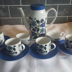 May include: A vintage floral tea set with a blue and white floral pattern. The set includes a teapot, creamer, sugar bowl, and six cups and saucers.