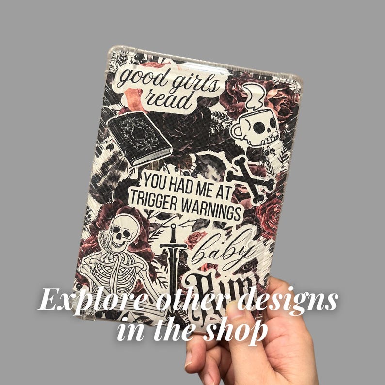 Puede incluir: Un cuaderno blanco y negro con un dise&ntilde;o floral y varias pegatinas. Las pegatinas incluyen una calavera, una espada, un libro y texto que dice "good girls read", "you had me at trigger warnings", y "baby".