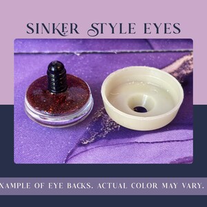 May include: Sinker style eyes featuring a dark red glittery circular front piece with a black plastic post and a separate light beige plastic washer back. The text SINKER STYLE EYES and EXAMPLE OF EYE BACKS. ACTUAL COLOR MAY VARY. is visible.