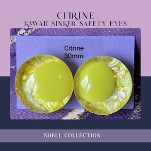 May include: Two circular 30mm Citrine Kawaii Sinker Safety Eyes featuring a solid bright yellow center surrounded by a translucent yellow border filled with iridescent shell fragments, mounted on a light purple card with the text Citrine 30mm.