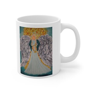 Puede incluir: Taza de cer&aacute;mica blanca con una pintura colorida de un &aacute;ngel con alas, tocando un arpa. El &aacute;ngel lleva un vestido azul y tiene el pelo largo y rubio. El fondo es un cielo azul con nubes amarillas y naranjas.