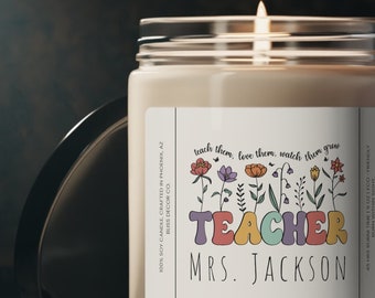 May include: A beige candle with a white label that reads "teach them, love them, watch them grow TEACHER MRS. JACKSON". The label has a colorful floral design.