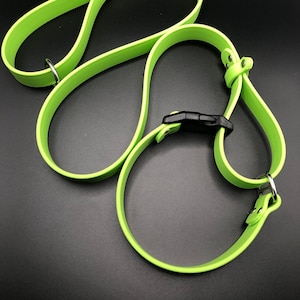 May include: Three lime green dog collars with silver D-rings and a black plastic buckle. The collars are arranged in a figure eight shape.
